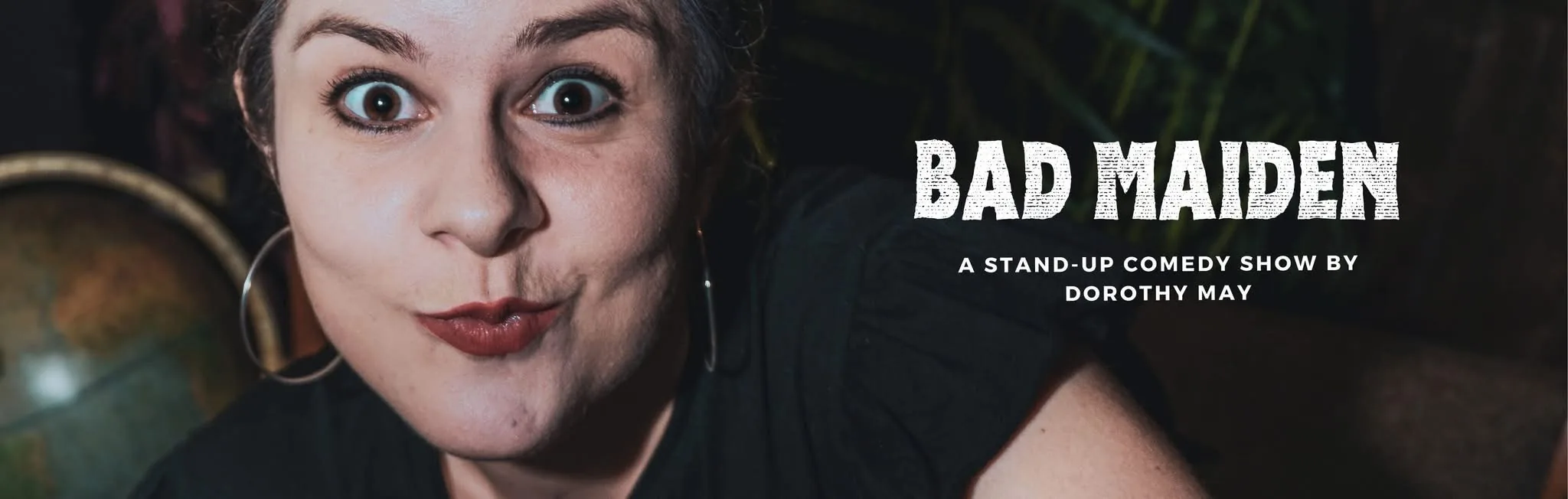 Dorothy May, close up and wide-eyed, next to the words Bad Maiden — a stand-up comedy show by Dorothy May